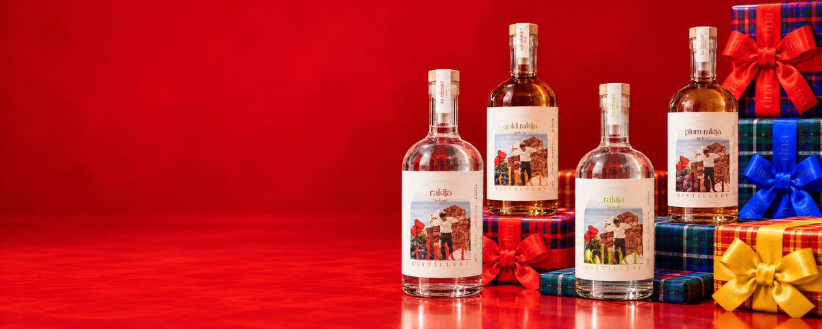 Classic, Gold, Pear and Plum rakija bottles with colourful tartan Christmas gifts on a red background.